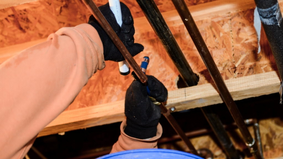 Plumber's hands attaching pipe